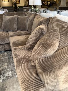 a large sectional couch in a store with lots of pillows on top of the couch