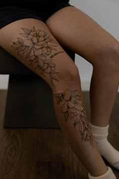 a woman's legs with flowers tattooed on them