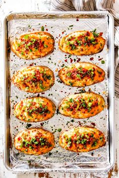 baked potato skins on a baking sheet with herbs and seasoning sprinkles