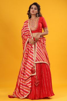 Red gota patti embroidered set featuring silk dupatta set. It comes with a beautiful striped multicolor embroidered dupatta & tassel attached. Pair it with beautiful jewelry to enhance your look. Shop online from Pure Elegance. Disclaimer: The actual product may vary slightly from the image. These are custom orders, hence expect slight variation in color, placement of the motif, or buta. ESTIMATED DELIVERYBecause this is a custom order, it would take about 4 weeks from the date of purchase. RETU Red Raw Silk Dupatta With Gota Work, Red Dola Silk Anarkali Set With Gota Work, Red Banarasi Silk Sets With Gota Work, Red Dola Silk Choli With Gota Work, Red Dola Silk Dupatta With Gota Work, Bohemian Red Dupatta With Border, Semi-stitched Red Dupatta With Intricate Embroidery, Red Semi-stitched Silk Dupatta, Red Semi-stitched Sequined Dupatta