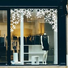 a mannequin in front of a store window with snowflakes on it