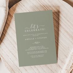 a wedding card on top of a wooden table next to a white towel and napkin