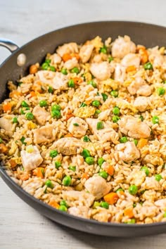 a pan filled with rice and vegetables on top of a table