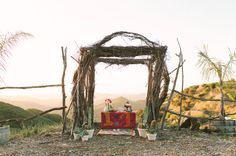 an outdoor altar with potted plants and flowers on the ground in front of it