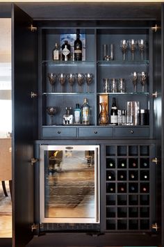 a wine cabinet with many bottles and glasses on it