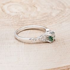 a close up of a ring on a wooden surface with a stone in the middle