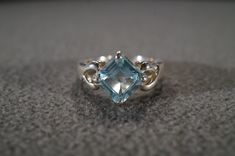 I am offering you this vintage sterling silver Art Deco style band ring with a gorgeous prong set trillion triangle shaped, genuine blue topaz stone. There is a regal influence in the design here, very nice! There is fabulous design setting. It measures app. 3/4 inch, by app. 1/4 inch. It has color saturation and intensity that is endless, as seen in the provided pictures. What an eye catcher! It has the classic highly desired solid setting that is very thick and substantial, giving this ring al Formal Trillion Cut Topaz Ring In Fine Jewelry Style, Formal Trillion Cut Topaz Fine Jewelry Ring, Silver Blue Topaz Ring With Diamond Cut, Unique Blue Topaz Ring For Formal Occasions, Anniversary Topaz Ring With Accent Stones, Trillion Cut, Anniversary Trillion Cut Topaz Ring With Accent Stones, Trillion Cut Topaz Jewelry For Anniversary, Trillion Cut Blue Topaz Ring With Accent Stones, Trillion Cut Topaz Ring With Accent Stones