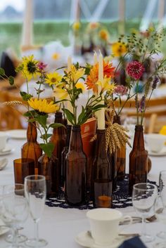 a table topped with lots of bottles filled with flowers