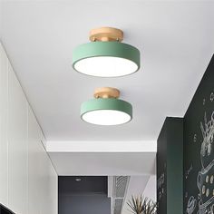 two circular lights hang from the ceiling above a kitchen counter and dining room table in front of a chalkboard wall