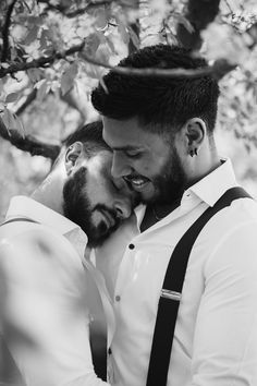 two men hugging each other under a tree