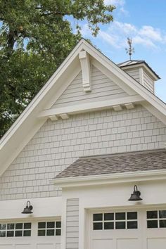 a white house with two garage doors and windows