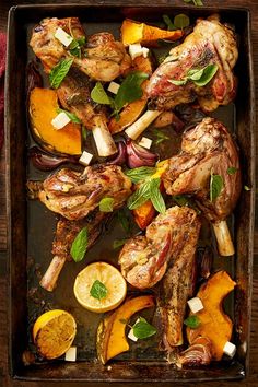 chicken and vegetables on a tray with lemons