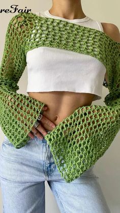 a woman with her hands on her hips wearing a green knitted cropped top