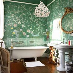 an old fashioned bathroom with green wallpaper and white bathtub in the middle of it