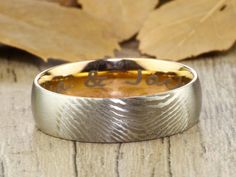 a wedding band that has been engraved with the word love on it and is sitting on a wooden surface