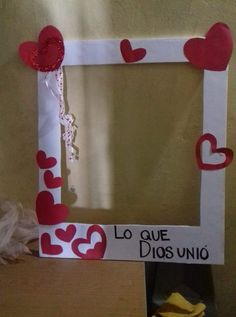 a white frame with red hearts hanging from it's sides and the words la que dios uno written in spanish