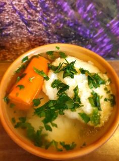 a bowl filled with mashed potatoes, carrots and parsley