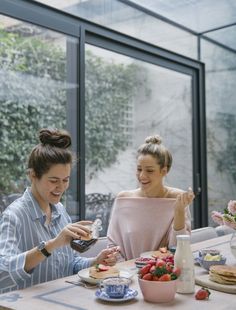 two women sitting at a table eating food