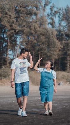 a man and woman are walking in the dirt