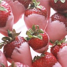 a bunch of strawberries with green leaves on them are arranged in a pyramid pattern