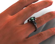 "This Lily engagement ring encapsulates the splendid beauty of nature. With a graceful Lily design and vibrant green Emerald, it's sure to give you a pleasant feeling each time you look at it. Choose this handmade beauty for the one who makes you truly happy. The band of this ring is crafted from pave diamonds 14kt black gold. It is carved at the top into a graceful design of Lily leaves, which surround black gold petals. At the very center is the highlight of the piece, a vivid, Colombian-green Green Vvs Clarity Rings For Proposal, Emerald Flower Ring Gift In Green, Unique Green Diamond Ring For Anniversary, Anniversary Emerald Flower Ring In Green, Anniversary Green Emerald Flower Ring, Nature Inspired Engagement Rings, Lily Leaves, Engagement Ring Nature, Two Tone Engagement Rings