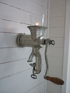 an old fashioned light fixture on the side of a wall with a candle in it