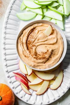 a white plate topped with an apple and cinnamon dip