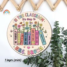 a wooden sign that says in this classroom it's books, flowers and butterflies