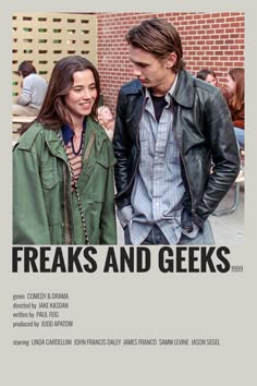 a man and woman standing next to each other in front of a brick wall with the words freaks and geeks on it