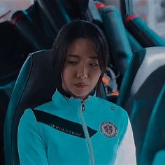 a woman in a blue jacket sitting on a bus