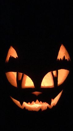 a carved pumpkin with glowing eyes in the dark