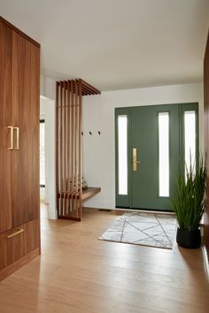 a green door is in the middle of a room with wood floors and wooden doors