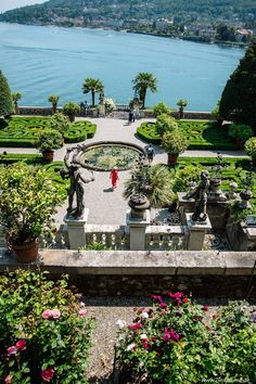 an aerial view of a formal garden with water in the background