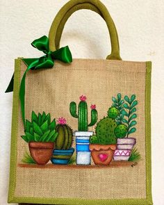 a handbag with potted plants painted on the front and green ribbon around it