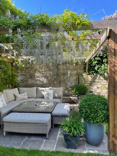 an outdoor living area with couches and potted plants