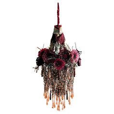 a chandelier with flowers and beads hanging from it