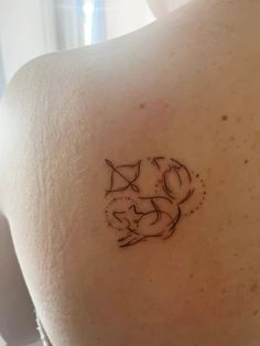 the back of a woman's shoulder with a cat tattoo on it