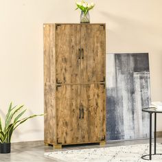 a tall wooden cabinet sitting next to a table with a vase on top of it