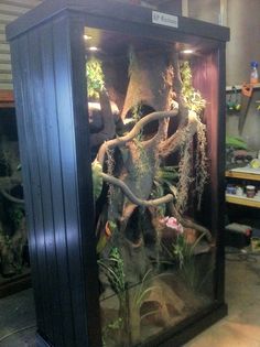 an elephant in a glass case with plants growing out of it