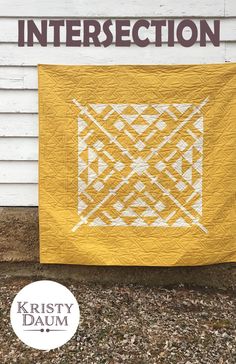 a yellow and white quilt on the side of a building