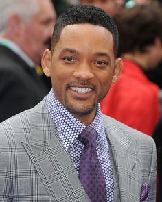 a man in a gray suit and purple tie