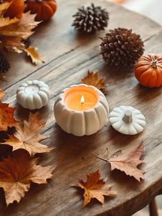 a table topped with candles and fall leaves