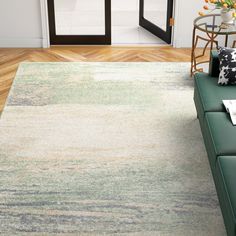 a living room with a green couch and white rug