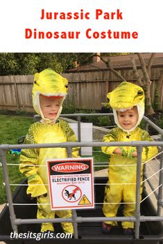 two children in yellow dinosaur costumes standing in a cart with a warning sign on it