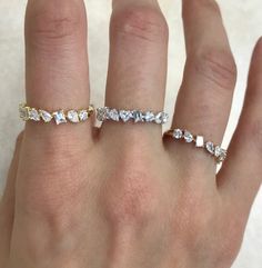 a woman's hand with two different rings on her left and the middle finger