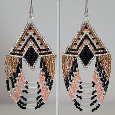 a pair of earrings with beads hanging from it