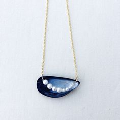 a blue necklace with pearls hanging from it