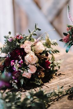 two bouquets of flowers sitting on top of a wooden table next to each other