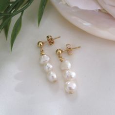 The 'Aphrodite' pearl earrings. Handmade with love, these high-quality beaded earrings are made with genuine freshwater pearls and 18K gold plated stud backs. The perfect match to the Aphrodite necklace on our page! Approximately 3.5cm drop length. ✯Packaged with care in a white organza bag ✯ The perfect gift for yourself or a loved one ✯ Items are all slightly unique as they are handmade to order ✯ To keep it in the best condition, avoid contact with water ♡ Free untracked first-class postage a Mother's Day Dangle Pearl Earrings, Gift Pearl Earrings With Round Beads, Mother's Day Pearl Drop Earrings, Pearl Drop Earrings For Her, Baroque Pearl Dangle Bridal Earrings For Gift, Baroque Pearl Bridal Dangle Earrings For Gift, White Drop Pearl Earrings For Mother's Day, Gift For Her: Pearl Drop Earrings, Mother's Day White Drop Pearl Earrings