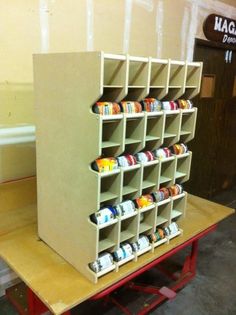 the shelves are made out of cardboard and have cups on them, as well as paintbrushes